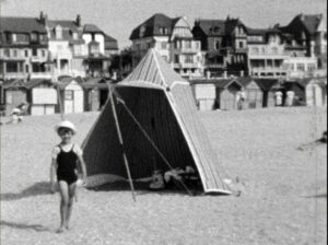 petite fille devant une tente sur la plage