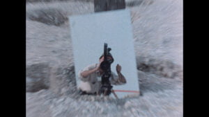 Un photographe prend une photo dans un environnement désertique et venteux avec son appareil.