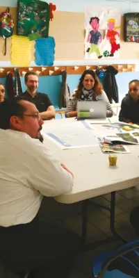 Groupe de personnes réunies autour d'une table pour une discussion.