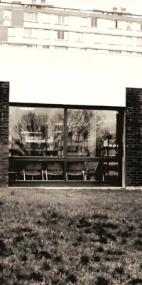 Une façade de bâtiment en briques avec des fenêtres reflétant un paysage urbain.