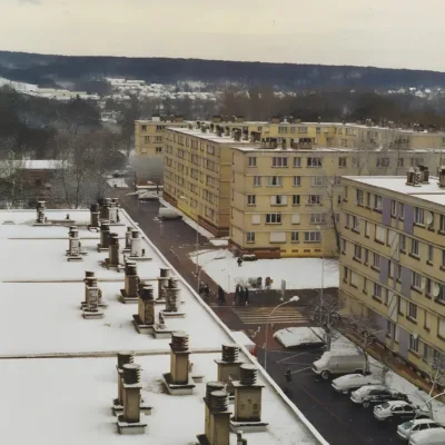 Vue d'ensemble d'immeubles recouverts de neige, en hiver, dans une ville.
