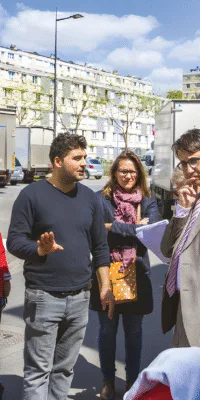 Des personnes discutent sur une voie publique en ville.
