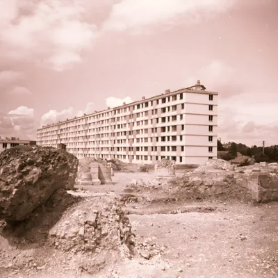 Un immeuble de logements en construction avec des décombres à l'arrière.