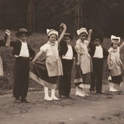 Un groupe d'enfants en costumes traditionnels se tiennent en rang, célébrant une fête locale.