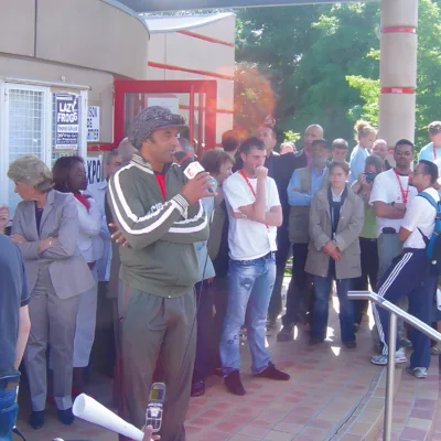Une foule d'assistants écoute un orateur sur un podium extérieur.