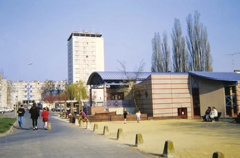 Vue d'un quartier résidentiel typique des années 80, avec des immeubles et une structure de service.