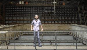 Un homme se tient devant une ancienne salle de spectacle en ruine.