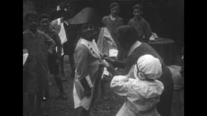 Photographie ancienne en noir et blanc d'un groupe d'enfants costumés en extérieur.