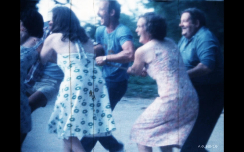 Des personnes dansent joyeusement dans un jardin, une scène nostalgique et colorée.